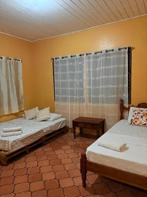 a room with two beds and a window at Casa Todah Av 5 in Liberia