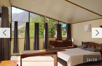 a bedroom with a bed and a couch and a window at Cielo Azul in Monteverde Costa Rica