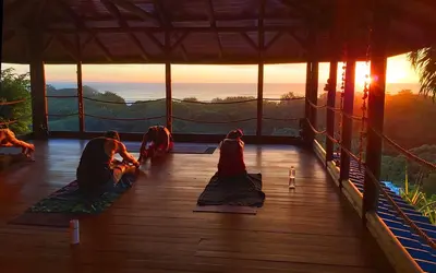 a group of people doing yoga on a wooden floor at Horizon Hotel & Yoga Center in Santa Teresa Beach