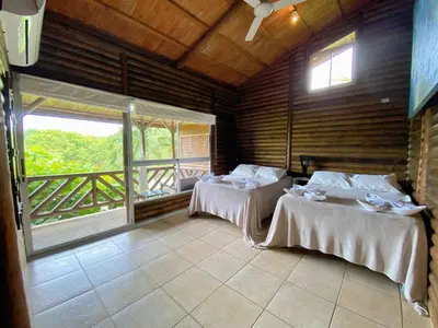 two beds in a room with a balcony at Horizon Hotel & Yoga Center in Santa Teresa Beach