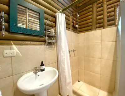 a bathroom with a sink and a shower at Horizon Hotel & Yoga Center in Santa Teresa Beach