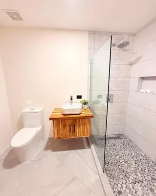 a bathroom with a toilet and a glass shower at Brianne's Place in Playa hermosa
