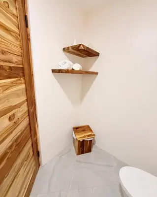 a bathroom with a toilet and a wooden shelf at Brianne's Place in Playa hermosa
