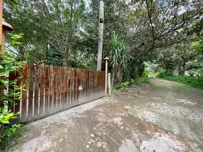 a wooden fence next to a dirt road with trees at Habitacion Atico in Curubandé