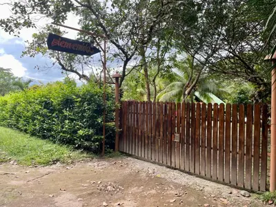 a wooden fence with a sign on top of it at Habitacion Atico in Curubandé
