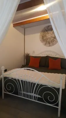 a white bed with orange pillows in a bedroom at Cozy Café Studio in El Copey