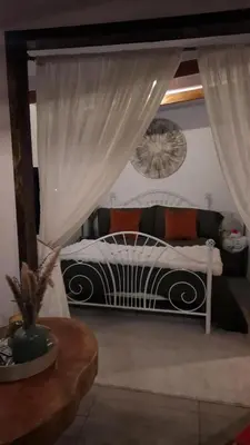 a bedroom with a white bed with curtains and a table at Cozy Café Studio in El Copey
