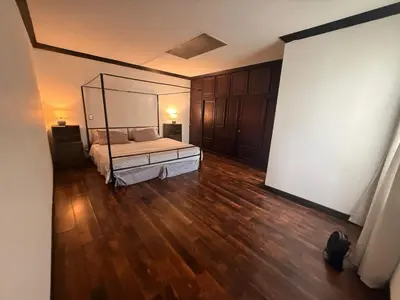 a bedroom with a bed and a wooden floor at DescansoAIRBNB in La Asunción