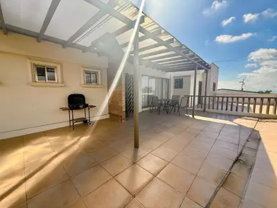 a patio with a white pergola on a balcony at DescansoAIRBNB in La Asunción