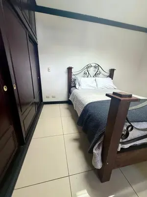 a bedroom with a bed and a table in it at DescansoAIRBNB in La Asunción