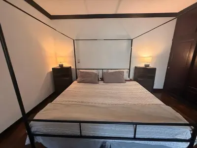a bedroom with a canopy bed with two night stands at DescansoAIRBNB in La Asunción