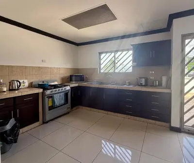 a kitchen with blue cabinets and a stove top oven at DescansoAIRBNB in La Asunción