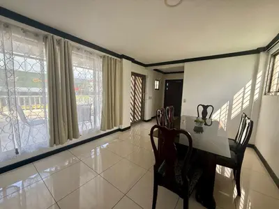 a dining room with a table and chairs and windows at DescansoAIRBNB in La Asunción