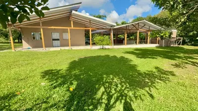 a house with a large lawn in front of it at Quinta Don Ebal in Guácimo