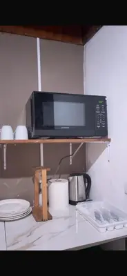 a microwave sitting on a shelf in a kitchen at Quinta Don Ebal in Guácimo