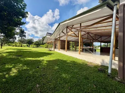a large building with a grass field next to it at Quinta Don Ebal in Guácimo