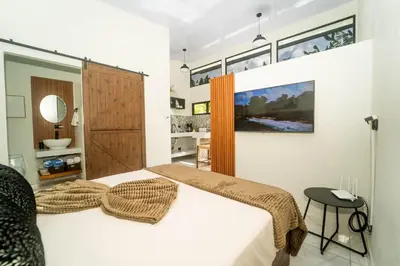 a bedroom with a large bed and a bathroom at Inta Tiny House in Fortuna