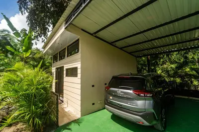 a car parked under a garage with a roof at Inta Tiny House in Fortuna