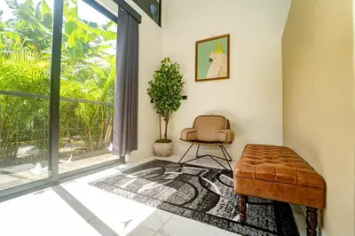 a living room with a chair and a window at Inta Tiny House in Fortuna