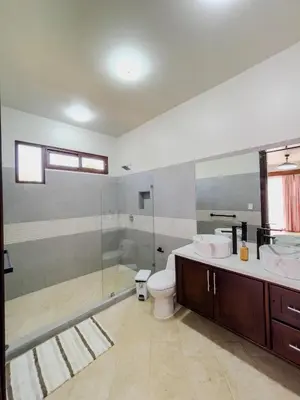 a bathroom with a toilet and a glass shower at Casa Pura Vida in Coco