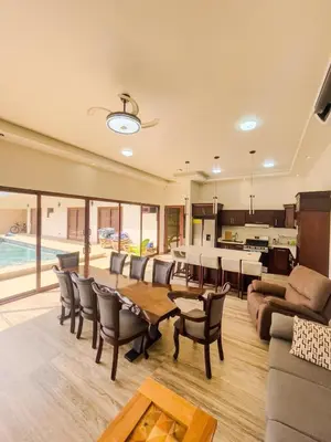 a living room with a table and chairs and a kitchen at Casa Pura Vida in Coco