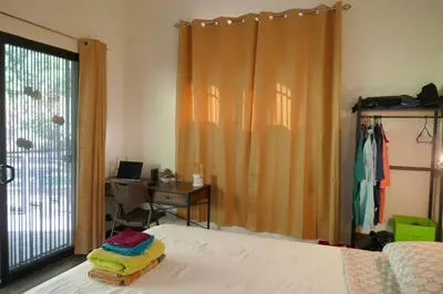 a bedroom with a bed and a desk and a window at Casa de la Diversidad - La Casita - Ojochal in Ojochal