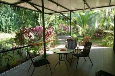 a patio with a table and chairs on a porch at Casa de la Diversidad - La Casita - Ojochal in Ojochal