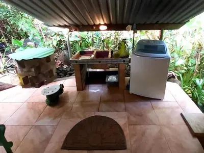 a patio with a table and a trash can at Wooden Cabin with deck Over Creek, walk to beach in Dominicalito