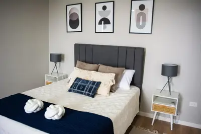 a bedroom with a bed with pillows and two lamps at Cabina Alto San Juan l Mountain Luxury Getaway in San Juan