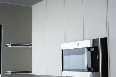 a microwave oven in a kitchen with white cabinets at Cabina Alto San Juan l Mountain Luxury Getaway in San Juan