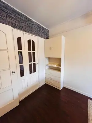 an empty room with white cabinets and a brick wall at Apolo Loft in Guápiles