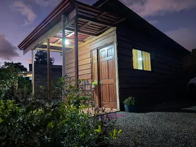 a small cabin with a wooden door in a yard at Magic Lodge - Cirrí, Naranjo