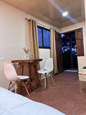 a bedroom with a bed and a table and chairs at Magic Lodge - Cirrí, Naranjo