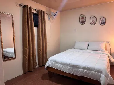 a small bedroom with a bed and a mirror at Magic Lodge - Cirrí, Naranjo