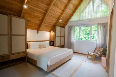 a bedroom with a large white bed and a window at Casa Terra - Modern House with Ocean Views in Santa Teresa Beach