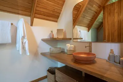 a bathroom with a wooden bowl on a counter at Casa Terra - Modern House with Ocean Views in Santa Teresa Beach
