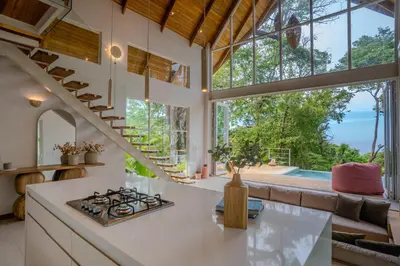 a kitchen with a stove and a large window at Casa Terra - Modern House with Ocean Views in Santa Teresa Beach