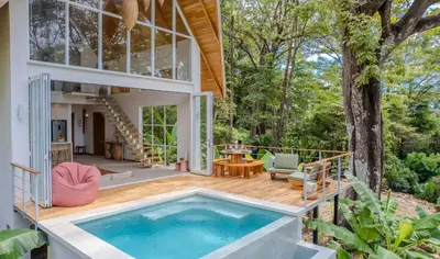 a pool on the deck of a house with a tree at Casa Terra - Modern House with Ocean Views in Santa Teresa Beach