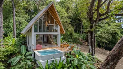 a tiny house in the woods with a hot tub at Casa Terra - Modern House with Ocean Views in Santa Teresa Beach
