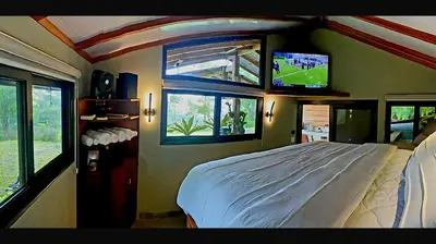 a bedroom with a bed and a tv on the wall at Finca Lilly in Upala