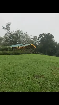 a large green field with a building in the background at Finca Lilly in Upala