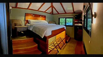 a bedroom with a large bed and a chair at Finca Lilly in Upala