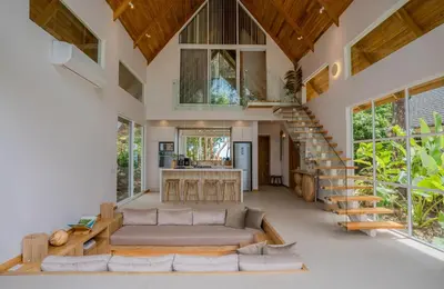 a living room with a couch and a staircase at Casa Solana - Modern House with Ocean Views in Santa Teresa Beach