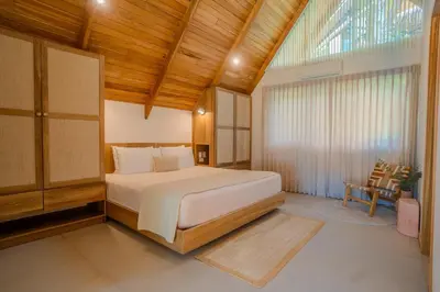 a bedroom with a bed and a chair in it at Casa Solana - Modern House with Ocean Views in Santa Teresa Beach