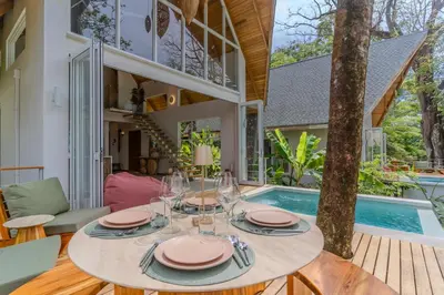 a dining room with a table and chairs and a pool at Casa Solana - Modern House with Ocean Views in Santa Teresa Beach