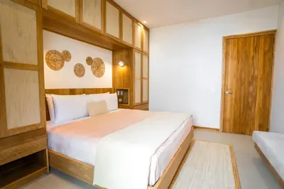 a bedroom with a large white bed and wooden walls at Casa Solana - Modern House with Ocean Views in Santa Teresa Beach