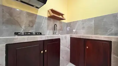 a kitchen with brown cabinets and a stove in it at Casita Pacifica in Playa Grande