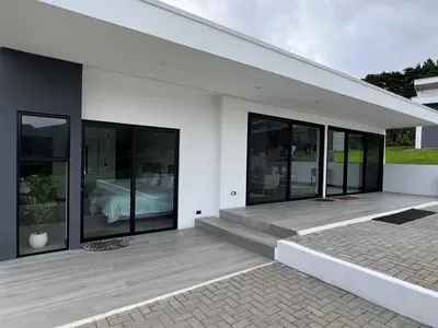 a white house with black windows and a bed at AO Buena Vista Home - Panoramic View in Concepción
