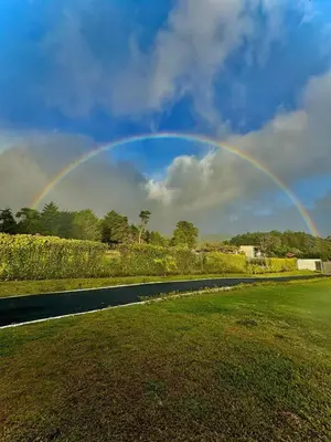 a rainbow in the sky over a field with a road at AO Buena Vista Home - Panoramic View in Concepción