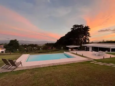 a swimming pool in a yard with a sunset at AO Buena Vista Home - Panoramic View in Concepción